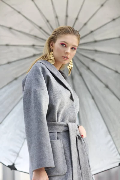 Mode portret van jonge elegante vrouw in grijze vacht, zwarte broek — Stockfoto
