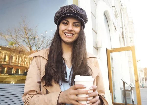 かわいい女の子はカフェwでコーヒーのカップと通りに立っています — ストック写真