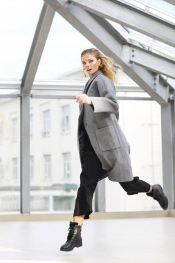 Gri ceket, siyah pantolon genç zarif kadının moda portresi