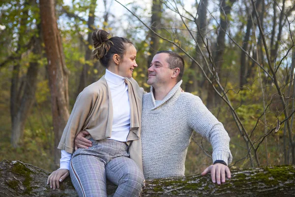 Belo casal sentado na árvore no parque abraçando — Fotografia de Stock