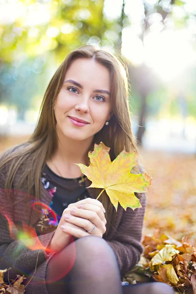 Χαρούμενη μελαχρινή κορίτσι που ποζάρει στο φθινόπωρο πάρκο σε κίτρινα δέντρα πίσω — Φωτογραφία Αρχείου