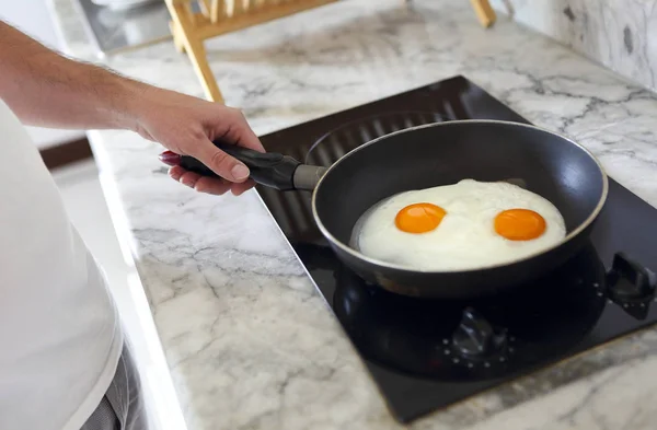 Imagem cortada de homem cozinhando ovos mexidos na frigideira — Fotografia de Stock