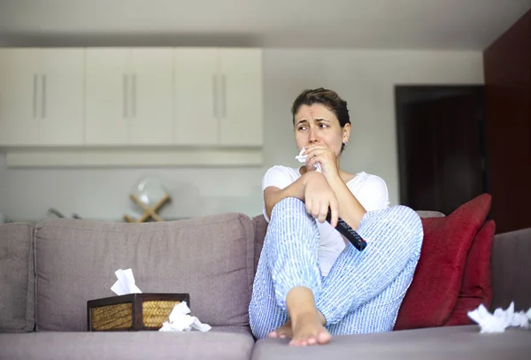 Mulher triste sentada no sofá e assistindo tv em casa — Fotografia de Stock