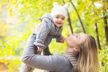 Anne ve onu küçük kızı oynamak sarılma üzerinde Autumn yürümek içinde n