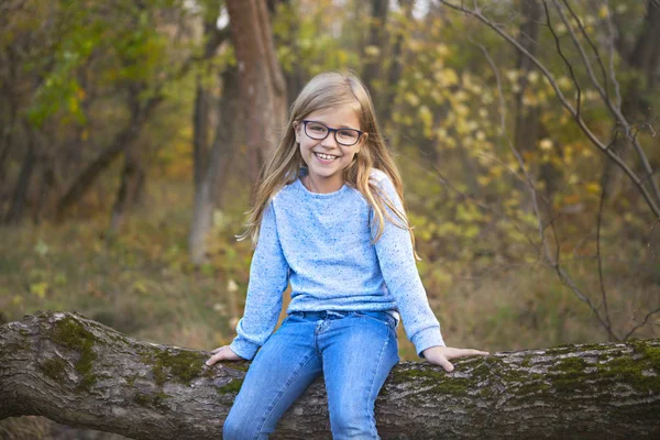 Portrait of a blonde girl with glasses outdoors in the park on t — Stock Photo, Image