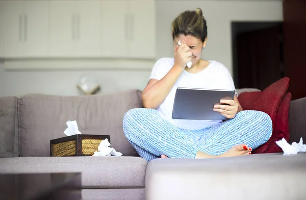 Sad kvinna tittar på film på Tablet PC innehar papper servetter — Stockfoto