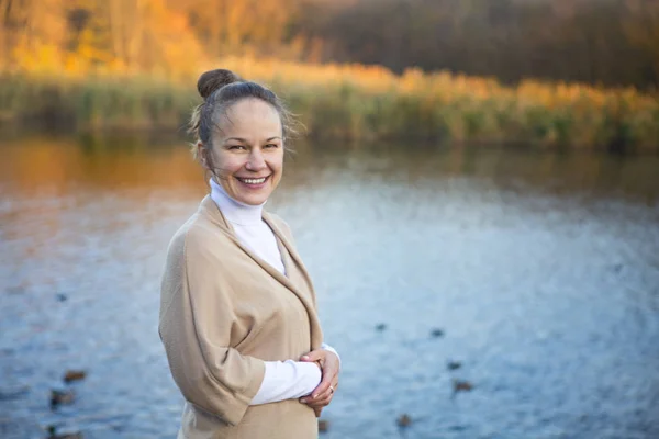 Молодая улыбающаяся женщина в осеннем парке — стоковое фото