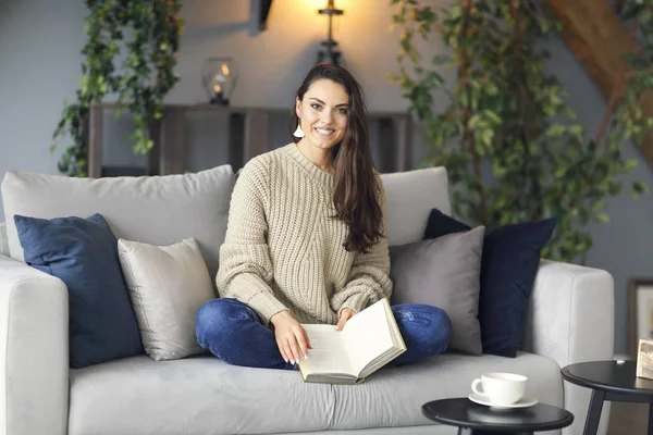 Giovane donna bruna felice con libro indossa maglione — Foto Stock