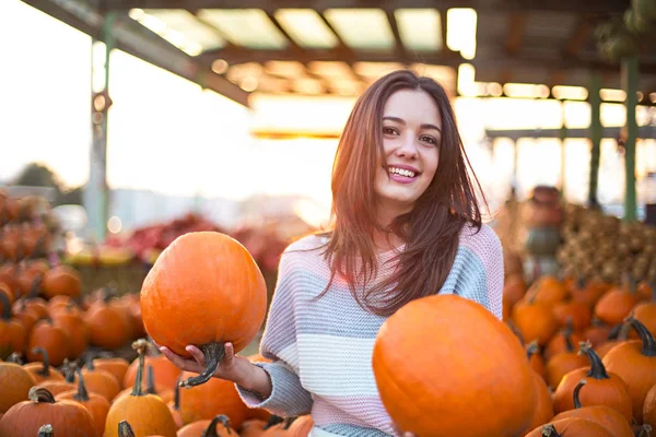 Fashionable beautiful young girl at the autumn pumpkin patch bac — Stock Photo, Image