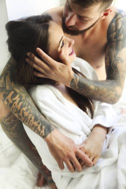 Yatakta birlikte yatarken seksi çift gülümsüyor 