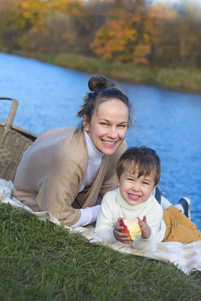 Joven madre bonita con su hijo pequeño en el parque de otoño —  Fotos de Stock