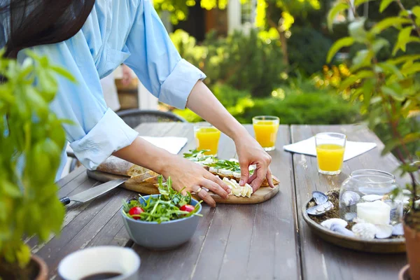 Mujer joven cocinando la cena en el hogar en el jardín —  Fotos de Stock