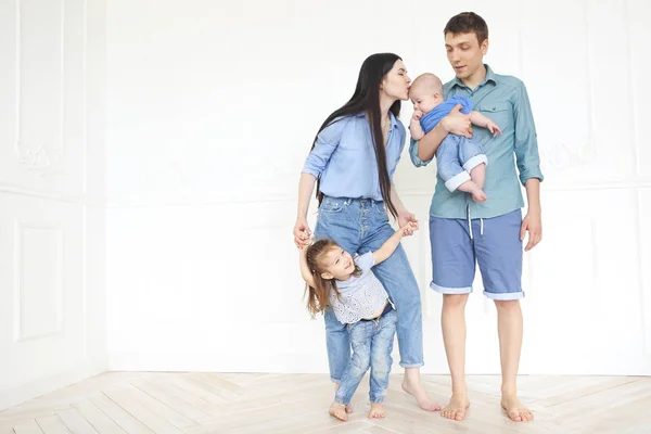 Felices padres jóvenes con sus adorables niños pequeños en casa —  Fotos de Stock