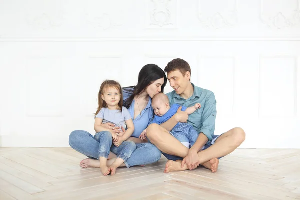 Jovens pais felizes com seus filhos adoráveis em casa — Fotografia de Stock