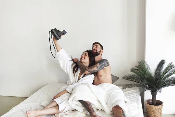 Para stwarzających w łóżku i biorąc selfie w godzinach porannych — Zdjęcie stockowe