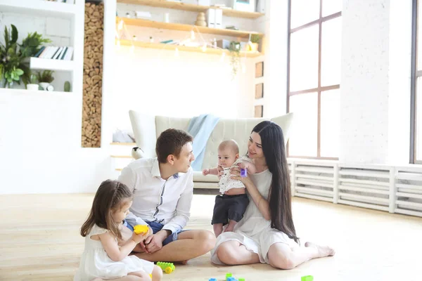 Famille heureuse jouer avec des blocs colorés à la maison — Photo