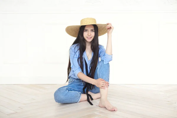 Mulher bonita em chapéu de palha e camisa azul olhando para a câmera — Fotografia de Stock