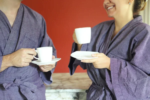 Pareja cariñosa en albornoz tomando café por la mañana — Foto de Stock