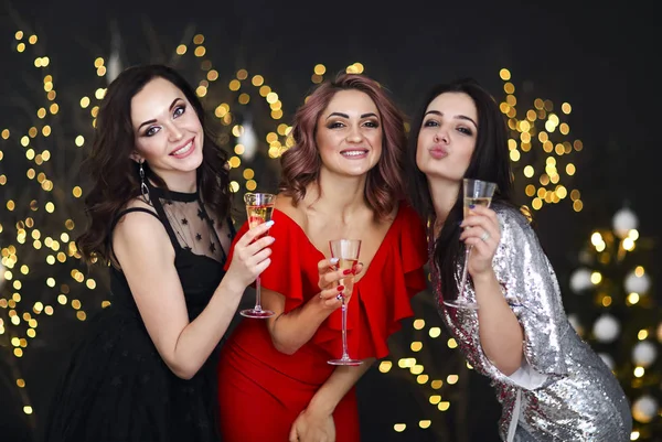 Mujeres sonrientes en vestidos de noche con copas de champán sobre —  Fotos de Stock