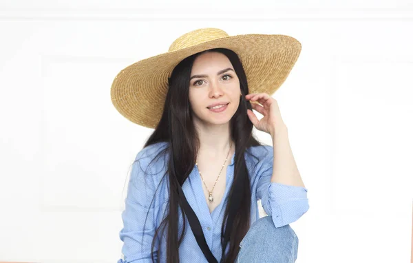 Hermosa mujer en sombrero de paja y camisa azul mirando a la cámara — Foto de Stock