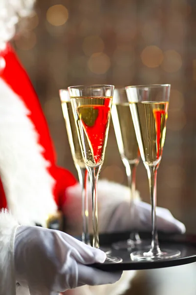 Papai Noel segurando copos de champanhe na bandeja — Fotografia de Stock