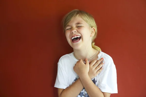 Hübsches emotionales Kind auf rotem Hintergrund. Kopierraum, Tageslicht — Stockfoto