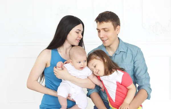 Glada unga föräldrar med sina söta små barn hemma — Stockfoto