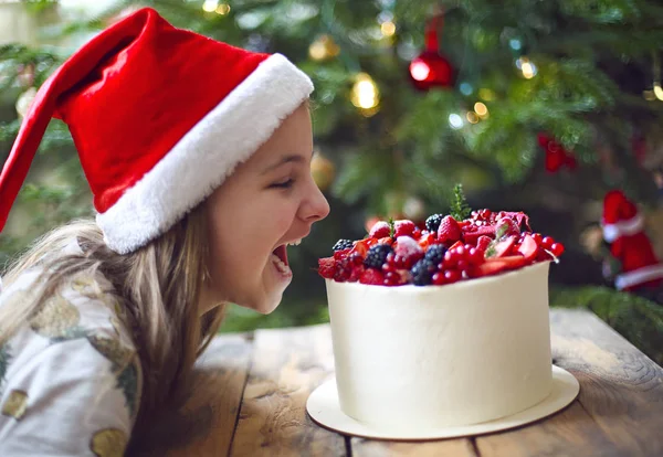 Рождественский торт украшен ягодами и маленькой девочкой — стоковое фото