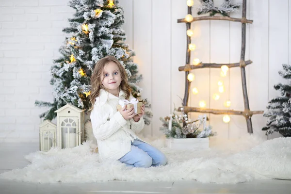 Девочка распаковывает рождественский подарок на рождественское украшение — стоковое фото