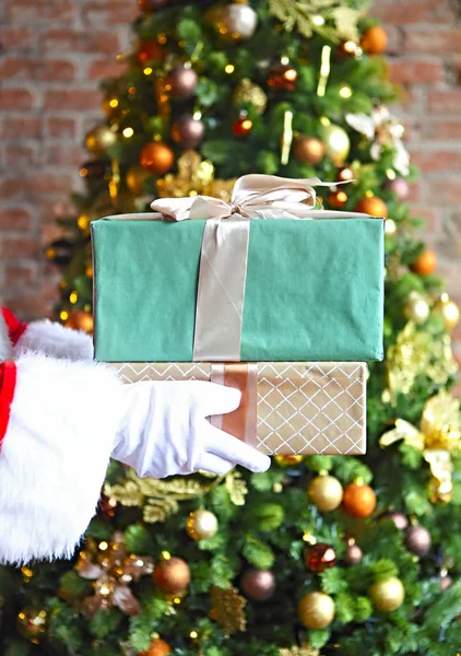 圣诞老人偷偷地把礼物盒放在圣诞树前 — 图库照片