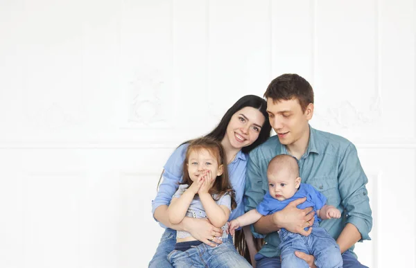 Happy young parents with their adorable little kids at home — Stock Photo, Image