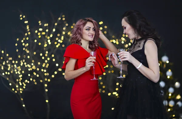 Smiling women in evening dresses with glasses of champagne over — Stock Photo, Image