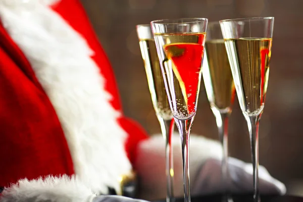 Санта Клаус держит бокалы для шампанского на подносе — стоковое фото