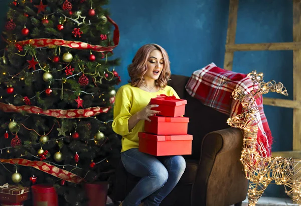 Усміхнена щаслива жінка з подарунковою коробкою над вітальнею на Різдво — стокове фото