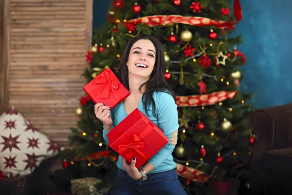 Noel'de oturma odası üzerinde hediye kutusu ile Gülümseyen mutlu kadın — Stok fotoğraf
