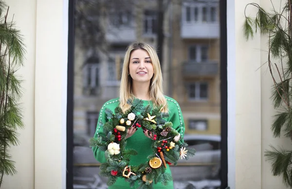 Dziewczyna trzyma Christmas wieniec zaznaczył przez siebie — Zdjęcie stockowe