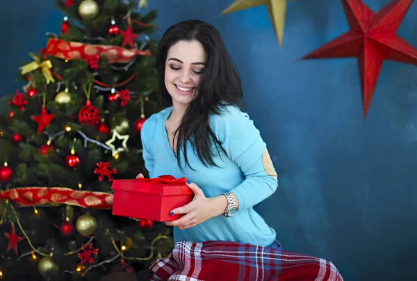 Улыбающаяся счастливая женщина с подарочной коробкой над гостиной на Рождество — стоковое фото