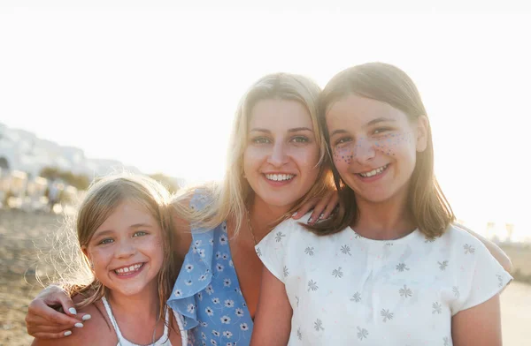 Jovem Alegre Abraçando Filhas Sorridentes Juntos Olhando Para Câmera Enquanto — Fotografia de Stock