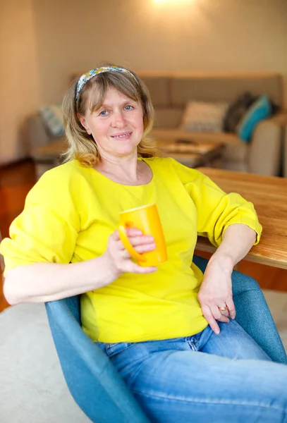 Positive Middle Aged Female Casual Yellow Shirt Jeans Sitting Table — Stock Photo, Image