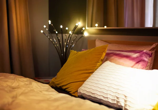 Wygodne Łóżko Różnymi Poduszkami Przytulnej Ciemnej Sypialni Wnętrza Retro Świecącą — Zdjęcie stockowe