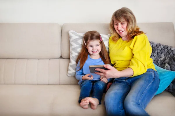 Cheerful Little Girl Her Grandmother Sitting Cozy Couch Watching Photos — Stock Photo, Image