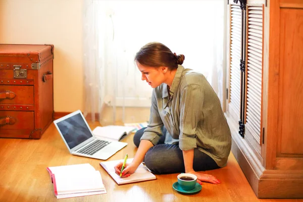 Joven Freelancer Sentada Suelo Cerca Taza Café Planificador Abierto Portátil — Foto de Stock