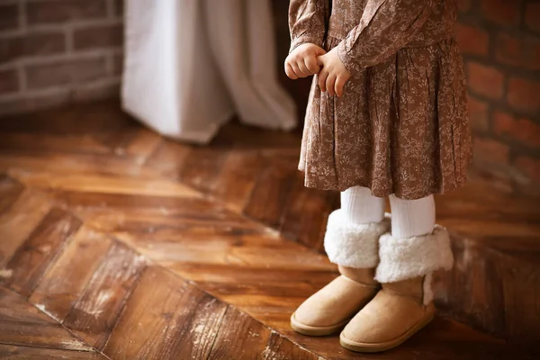 顔のない女の子で暖かい服や履物で立って茶色の寄木細工の床 — ストック写真