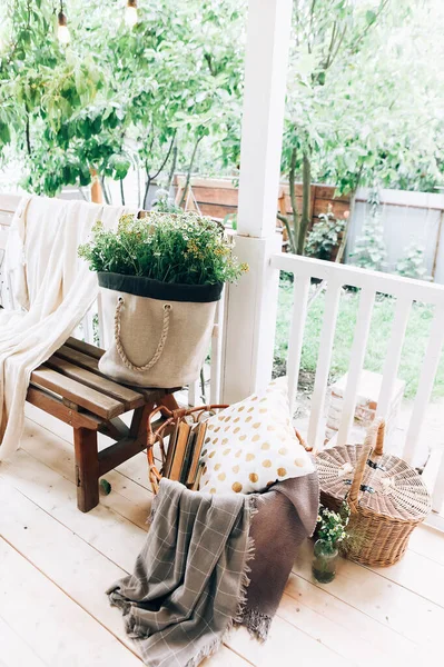緑の中庭を背景にベンチや花の束を持つ家の木製のテラスの高角度 — ストック写真