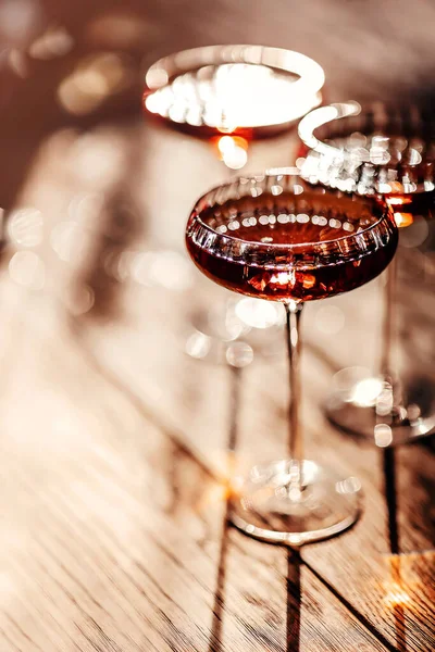 カフェの木のテーブルの上に赤アルコール飲料とクリスタルカクテルグラス — ストック写真