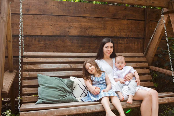 Joven Madre Encantada Sentada Sillón Con Adorables Hermanitos Terraza Casa — Foto de Stock