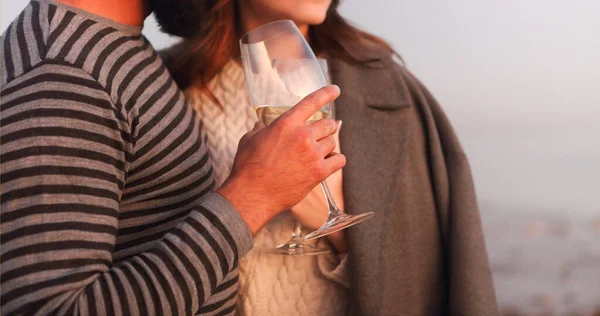 年轻夫妇爱在阳光下的岩石海岸喝白葡萄酒 — 图库照片