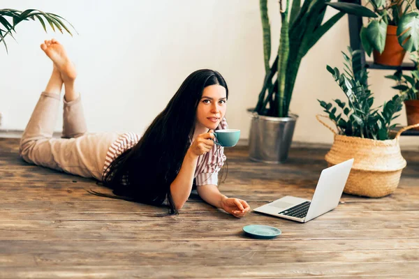 Lugn Kvinnlig Entreprenör Ligger Trägolv Hemma Med Laptop Och Dricka — Stockfoto