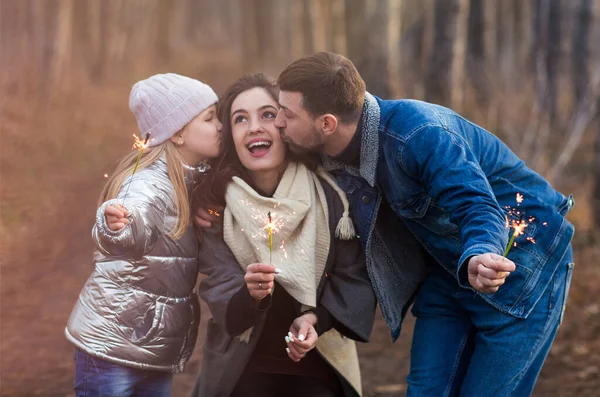 Wesoła Młoda Rodzina Córką Ubraną Ciepłe Ubrania Ogniem Rękach Obejmującym — Zdjęcie stockowe