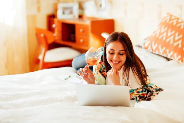 Youg Female Domestic Clothes Sitting Bed Glass Wine Browsing Netbook — Stock Photo, Image